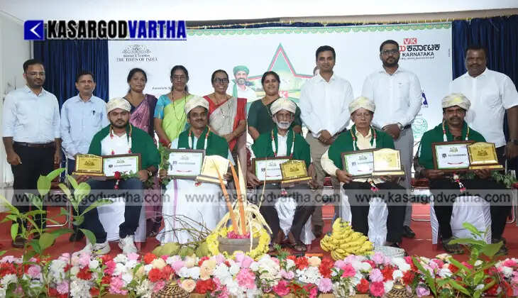 Successful farmer Razak Mogral proudly holding the Vijay Karnataka Best Farmer Award trophy along with dignitaries.