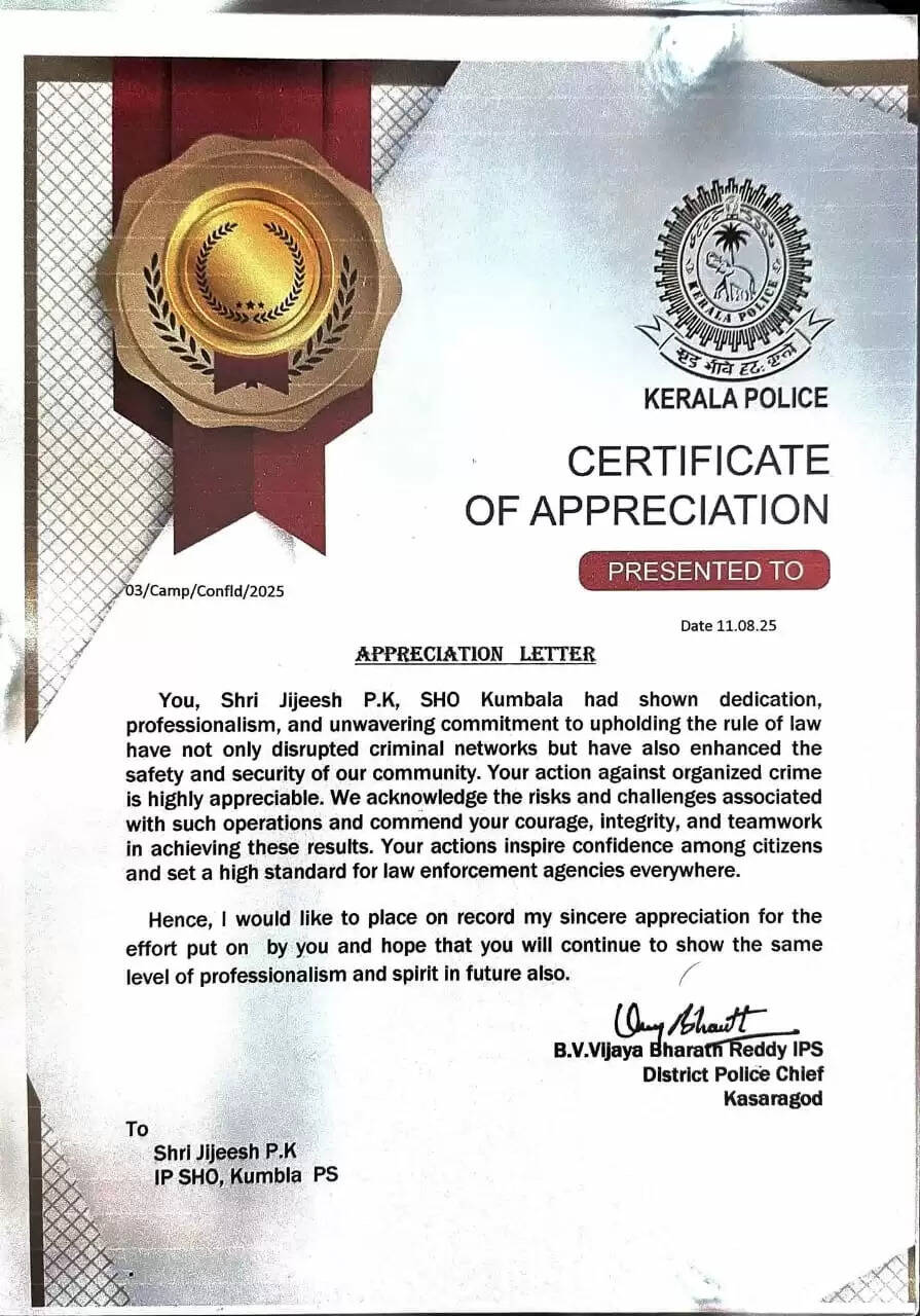 Kumbla SHO Jijeash PK receiving a letter of commendation from the District Police Chief of Kasaragod.