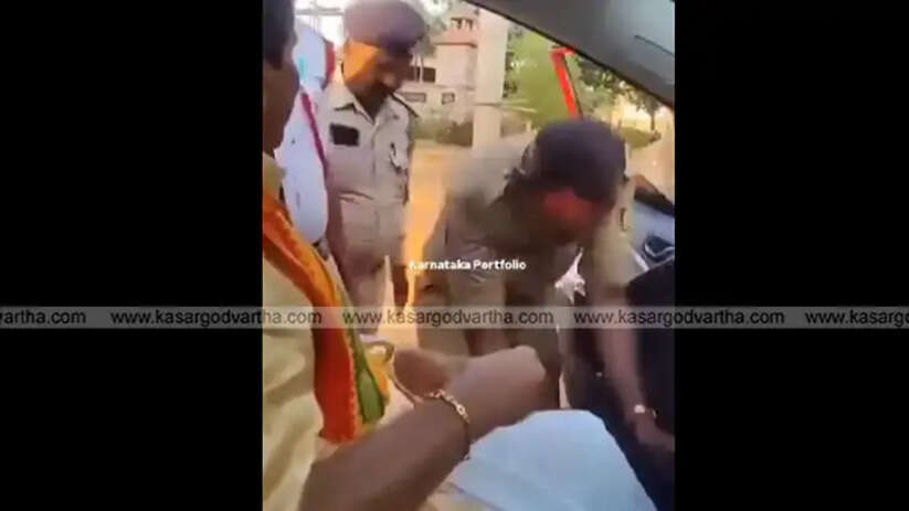 Karnataka police officers in uniform touching Siddanakolla Shivakumar Swamiji's feet and accepting money.