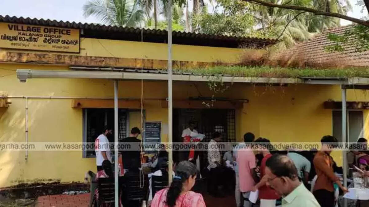 Image of a crowd outside a Kerala Village Office.