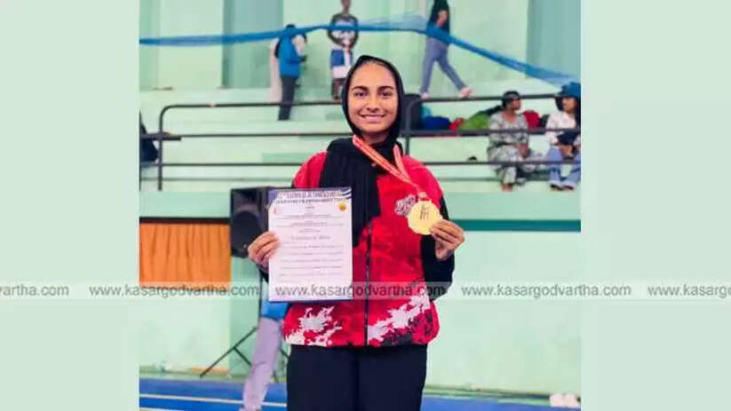 A M Fathima wearing a Taekwondo uniform and a Gold Medal.