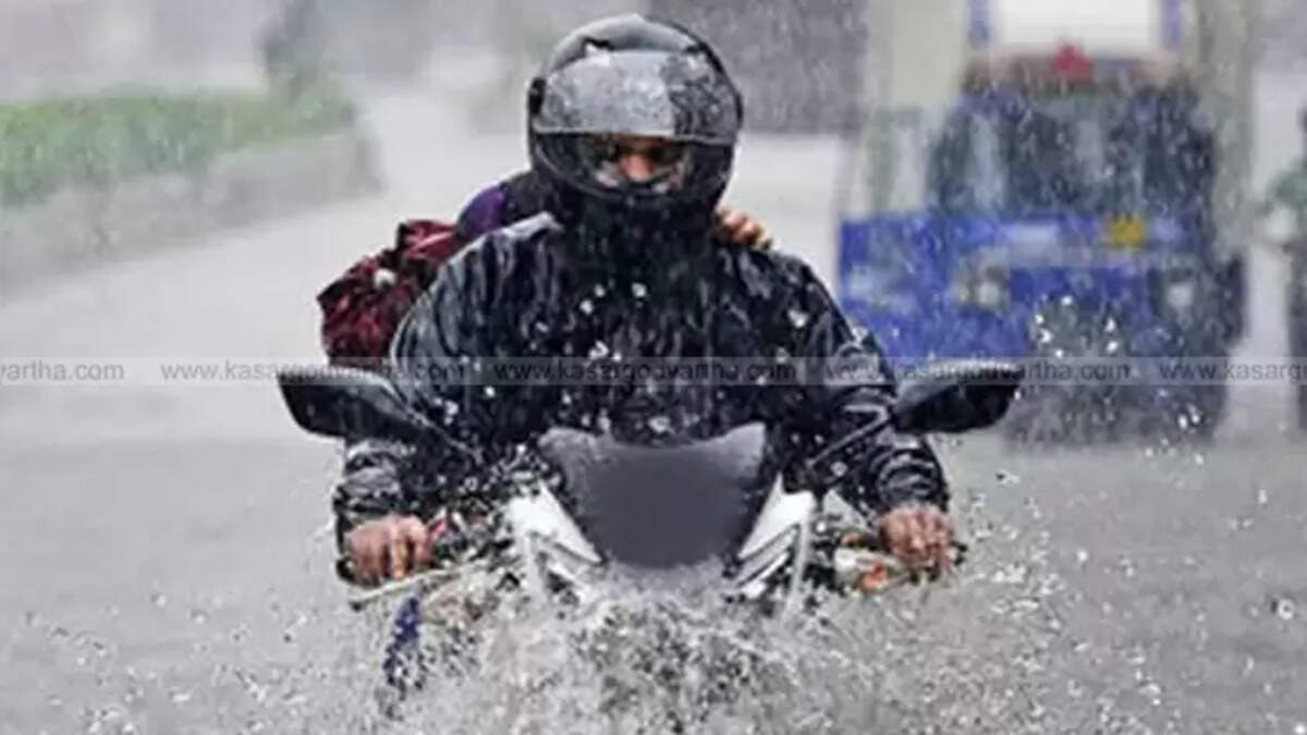Two-wheeler rider on wet Kerala road with helmet in rain