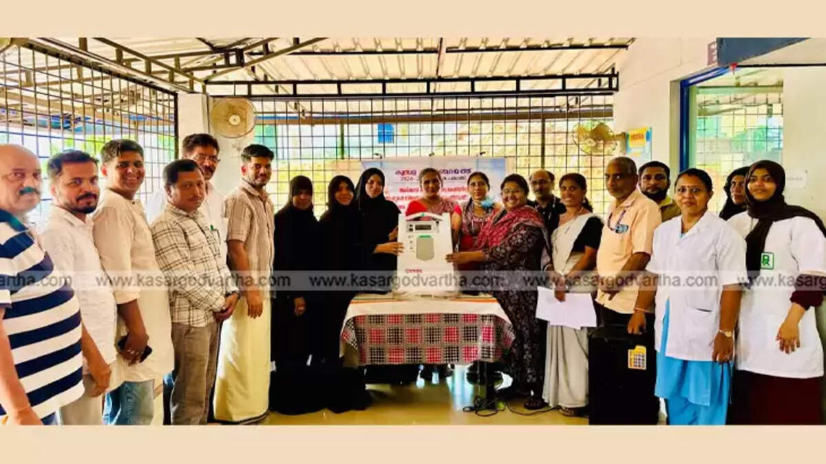 Kumbala Grama Panchayat President handing over an oxygen concentrator to a healthcare official. 