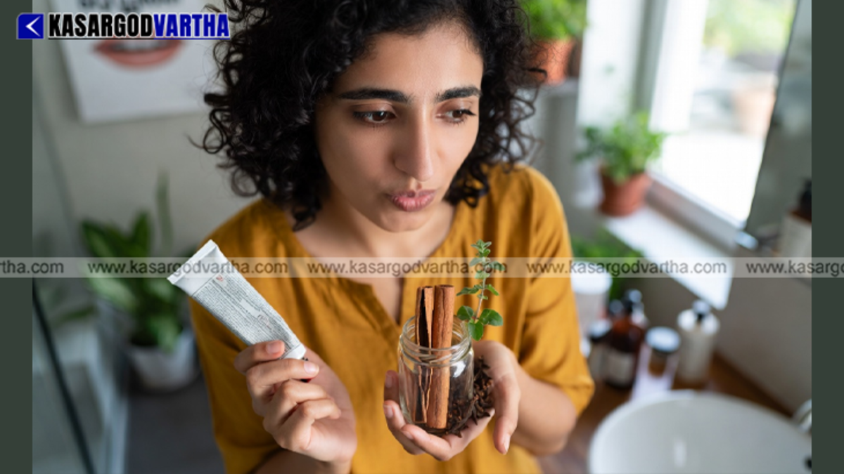A person squeezing herbal toothpaste onto a toothbrush