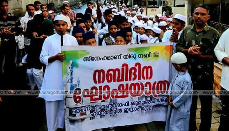 A large crowd of people participating in a colorful Nabidin procession in Kasaragod, Kerala.