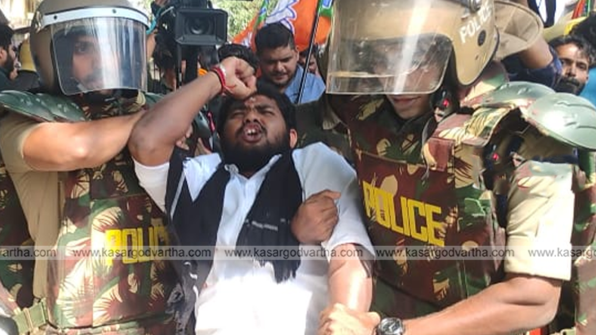 Yuva Morcha workers blocking a damaged road in Kasaragod during a protest.