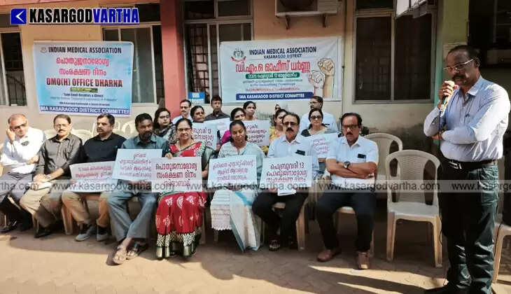 IMA doctors and members staging a dharna in front of the DMO office in Kanhangad with protest banners.