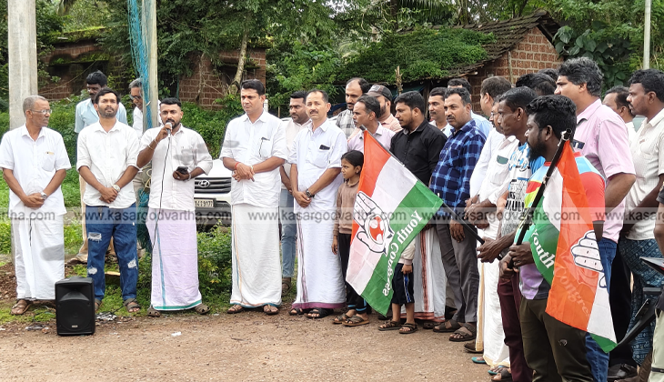 Youth Congress members protesting on a waterlogged road with a boat in Kasaragod.