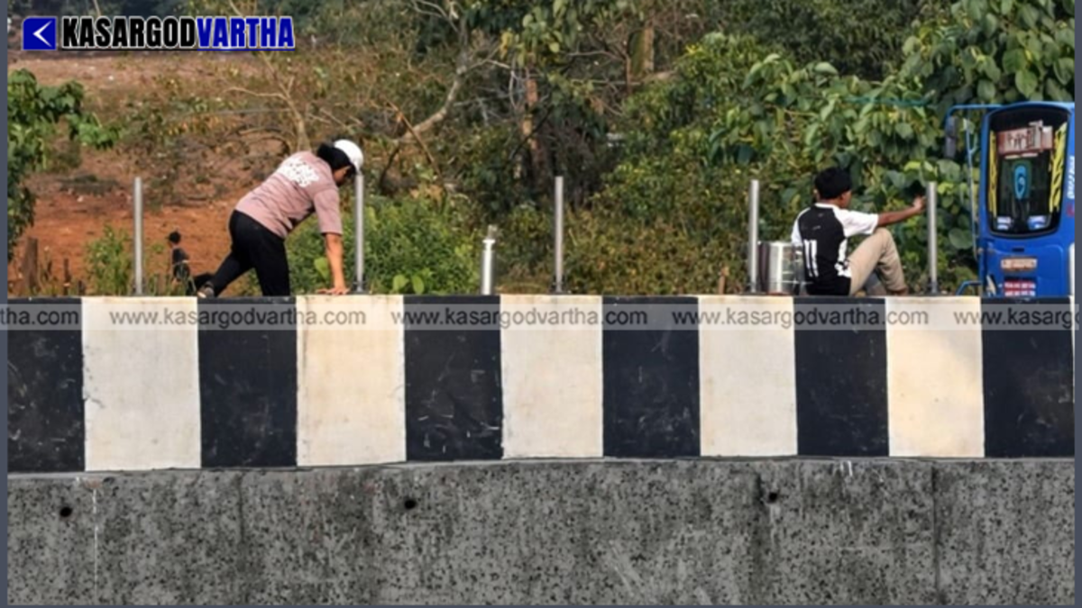  Students precariously climbing over a concrete highway median wall to cross the road.