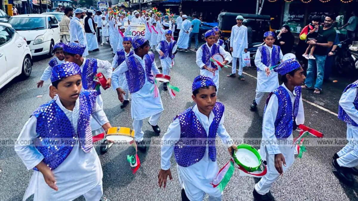 A large crowd of people participating in a colorful Nabidin procession in Kasaragod, Kerala.