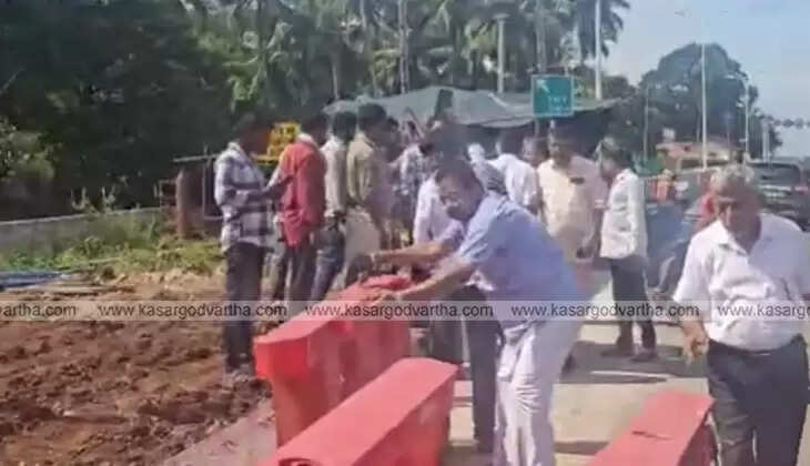 Public protesting near a toll booth under construction.