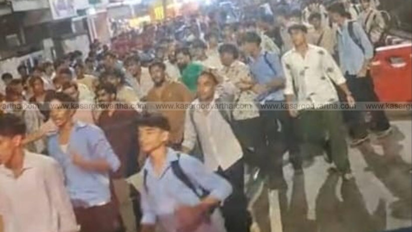  Police personnel near a school with a crowd of students