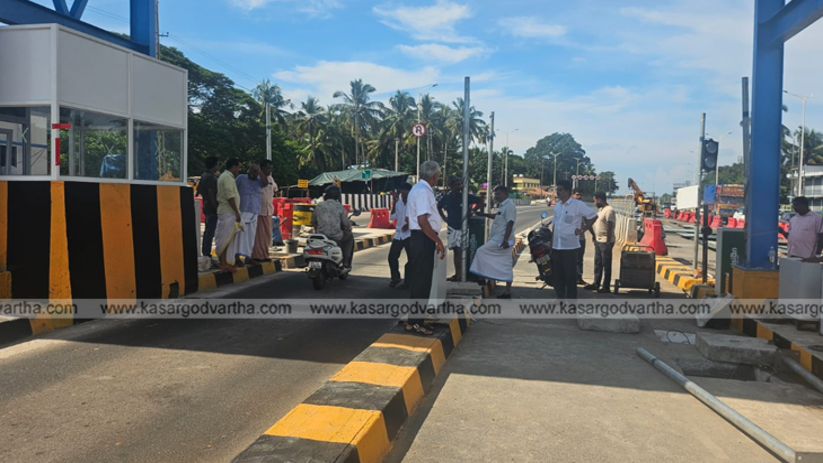 Public protesting near a toll booth under construction.
