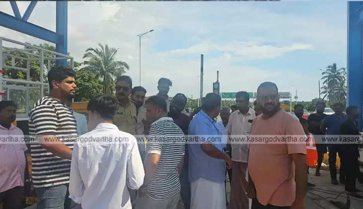 Public protesting near a toll booth under construction.