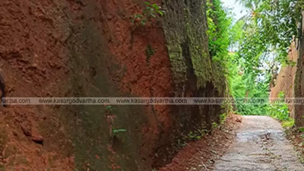 Narrow road in Pulikkunnu, Kasaragod with a collapsing hill nearby