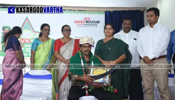 Successful farmer Razak Mogral proudly holding the Vijay Karnataka Best Farmer Award trophy along with dignitaries.