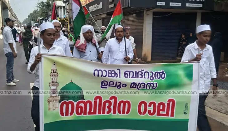 A large crowd of people participating in a colorful Nabidin procession in Kasaragod, Kerala.