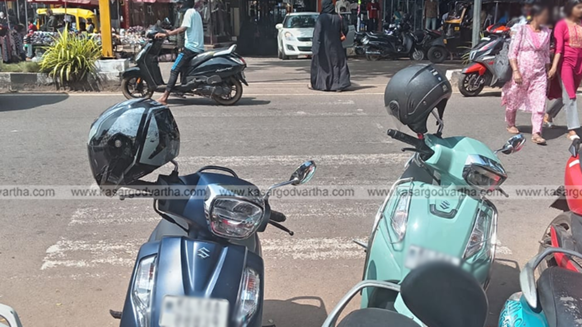 Faded zebra crossing on a busy road in Kasaragod with a pedestrian.