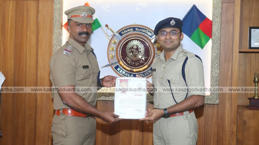 Kumbla SHO Jijeash PK receiving a letter of commendation from the District Police Chief of Kasaragod.
